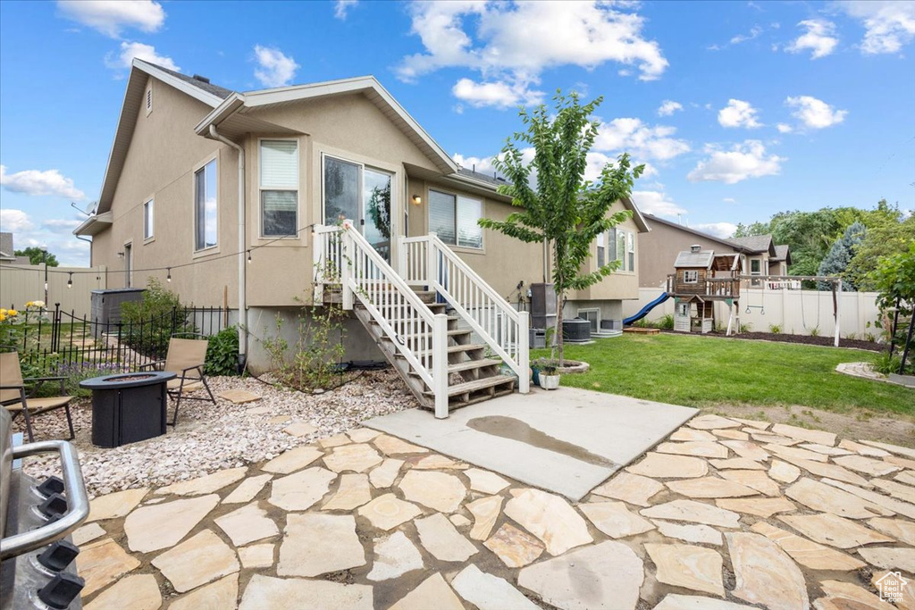 Back of property featuring a fire pit, a patio area, and stucco siding