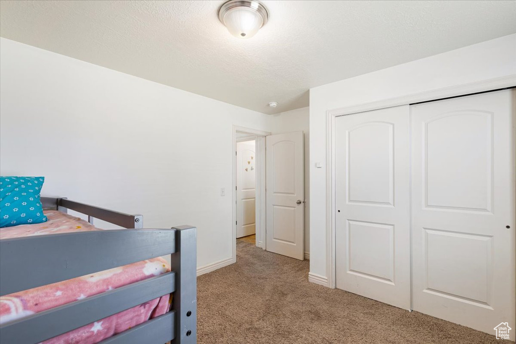 Bedroom featuring carpet flooring and a closet