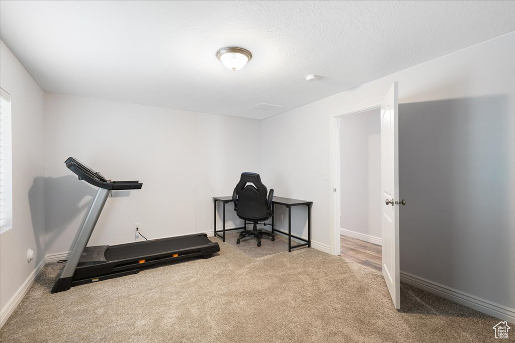 Workout room with carpet flooring and baseboards