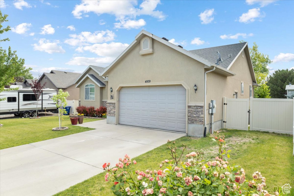 View of front of house featuring a gate, a garage, stucco siding, driveway, and stone siding