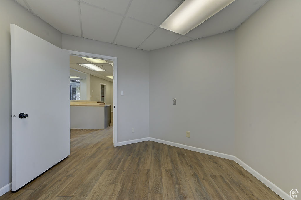 Empty room featuring wood finished floors and a paneled ceiling
