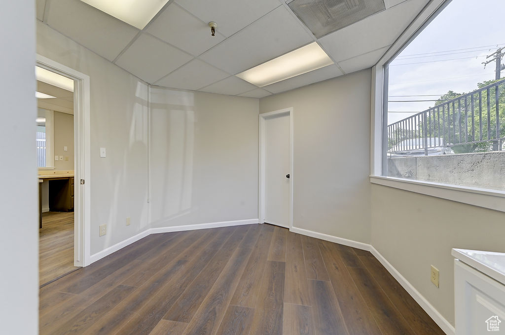 Empty room with baseboards and dark wood-style flooring