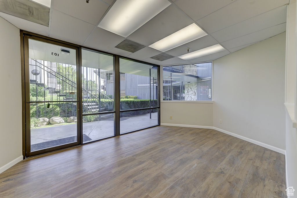 Spare room featuring plenty of natural light, wood finished floors, and floor to ceiling windows