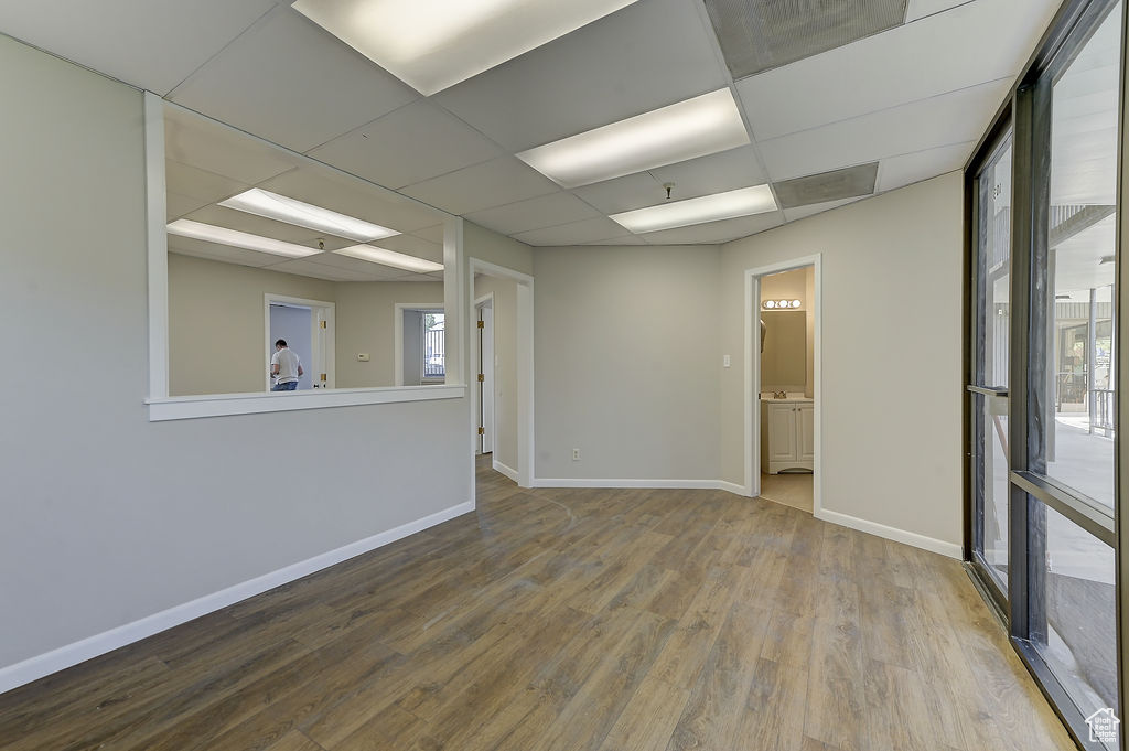 Spare room featuring wood finished floors and a drop ceiling