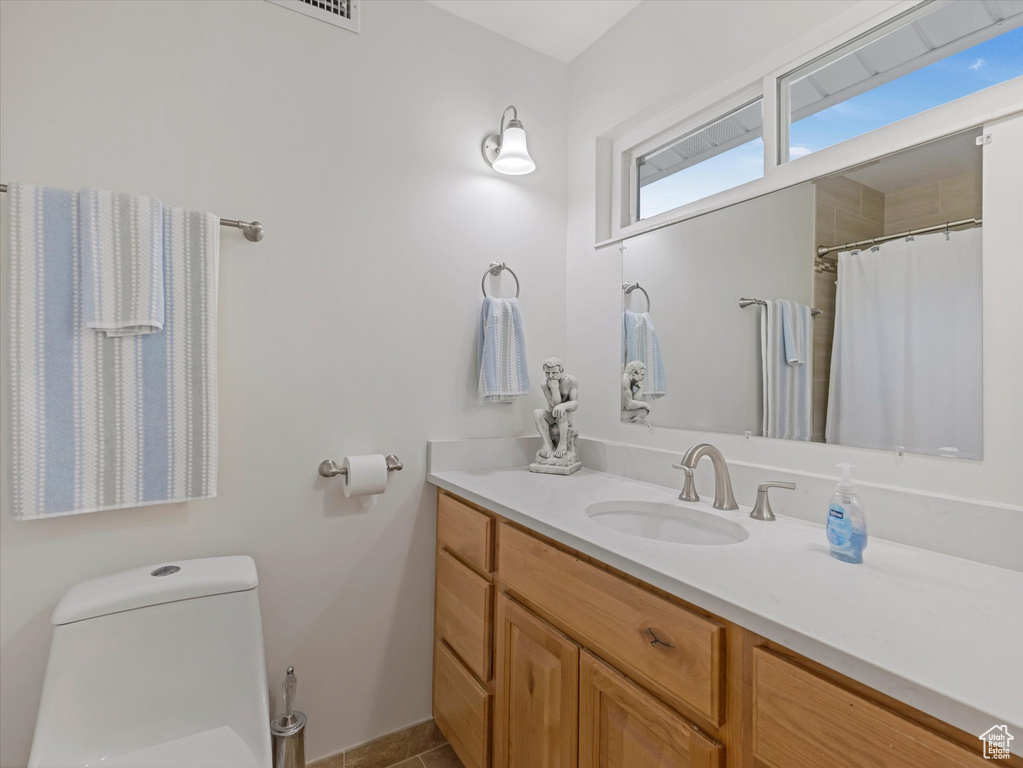 Bathroom featuring vanity, curtained shower, and tile patterned flooring