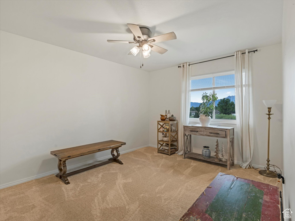 Sitting room featuring ceiling fan and carpet