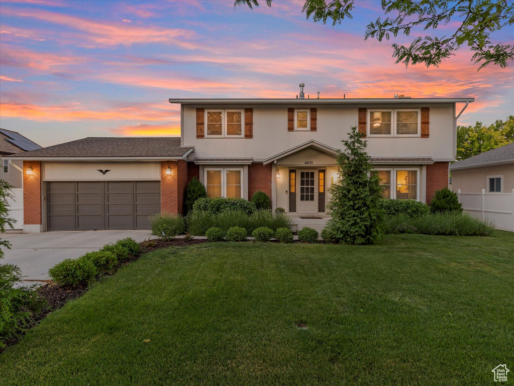 Traditional-style house featuring brick siding, a garage, and driveway