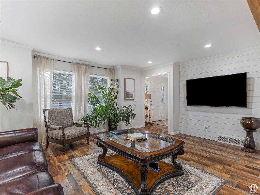 Living room with wood-type flooring, ornamental molding, and recessed lighting