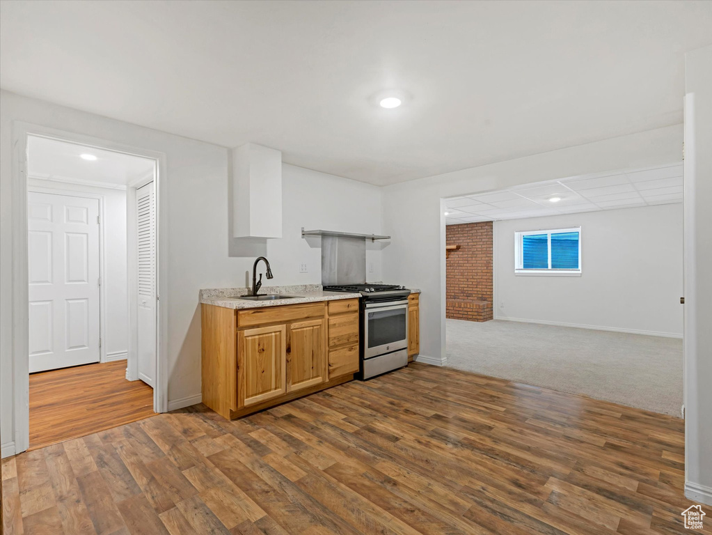 Kitchen with stainless steel gas stove, dark wood finished floors, recessed lighting, and open floor plan