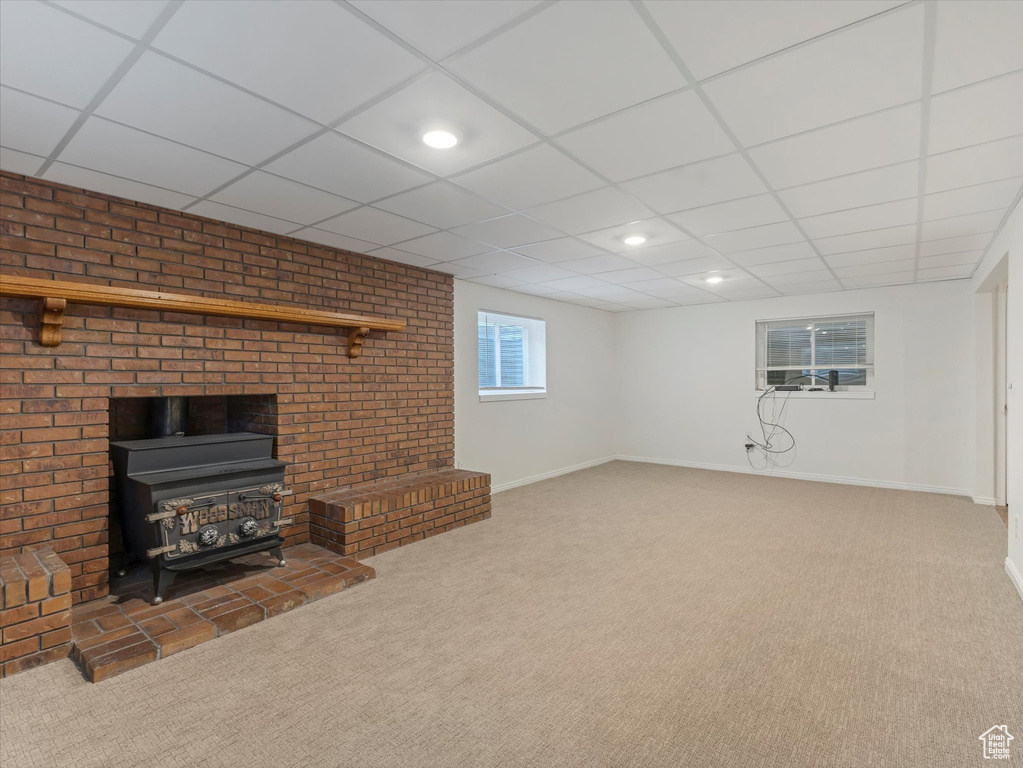 Unfurnished living room with a wood stove, carpet, recessed lighting, and a drop ceiling
