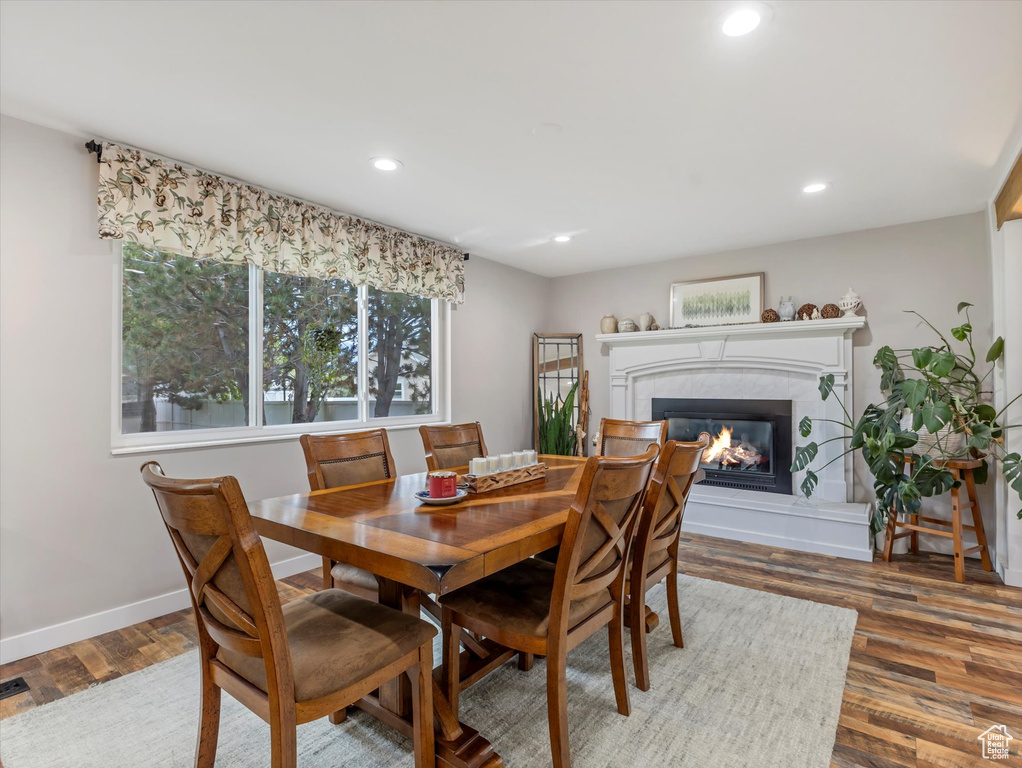 Dining area with a glass covered fireplace, recessed lighting, and wood finished floors