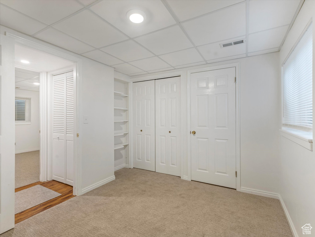 Unfurnished bedroom featuring carpet flooring and a drop ceiling