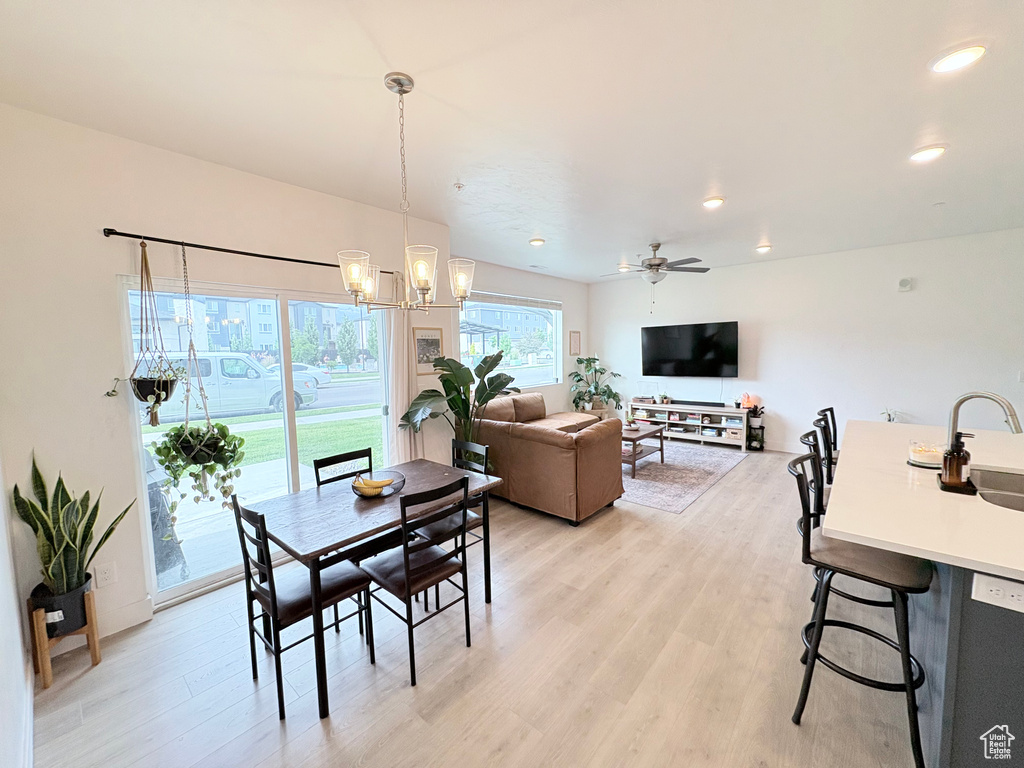 Dining room with light wood-style floors, a chandelier, recessed lighting, and ceiling fan