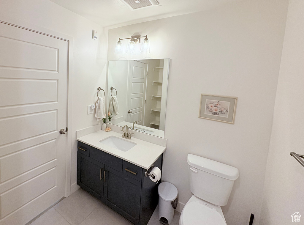 Half bathroom featuring tile patterned floors and vanity