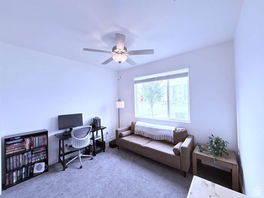 Carpeted office space featuring a ceiling fan