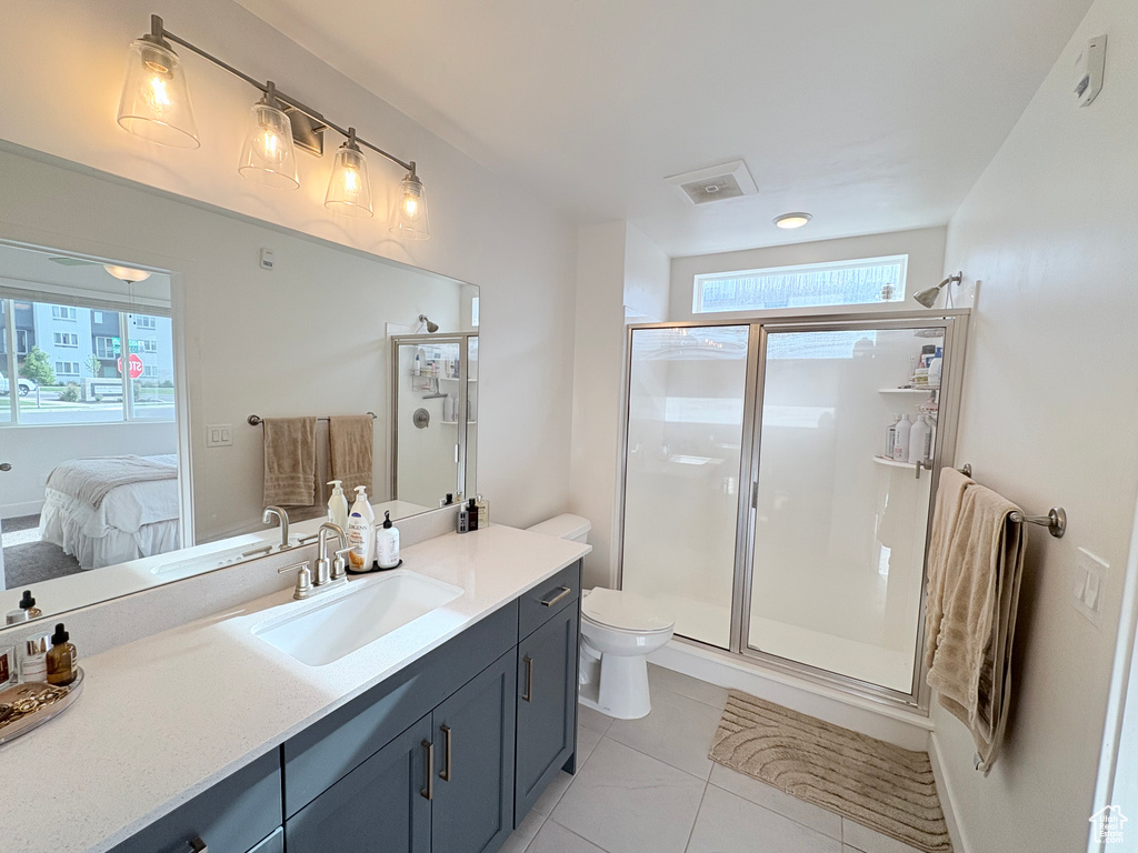 Ensuite bathroom featuring vanity, a stall shower, and tile patterned flooring
