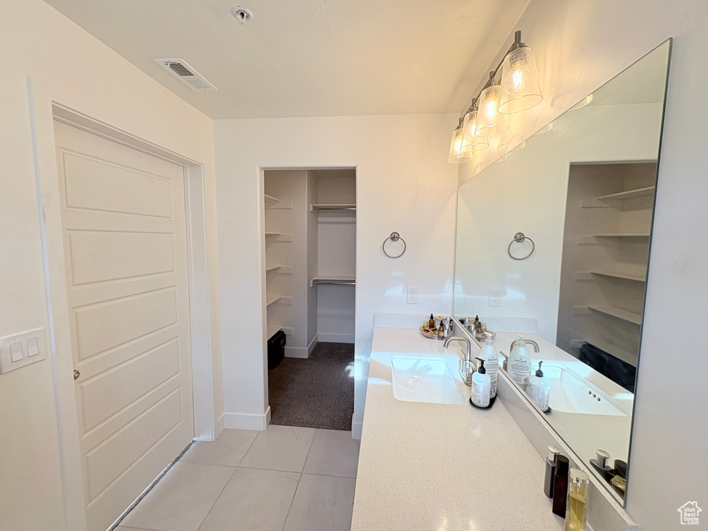 Bathroom with vanity, tile patterned floors, and a walk in closet