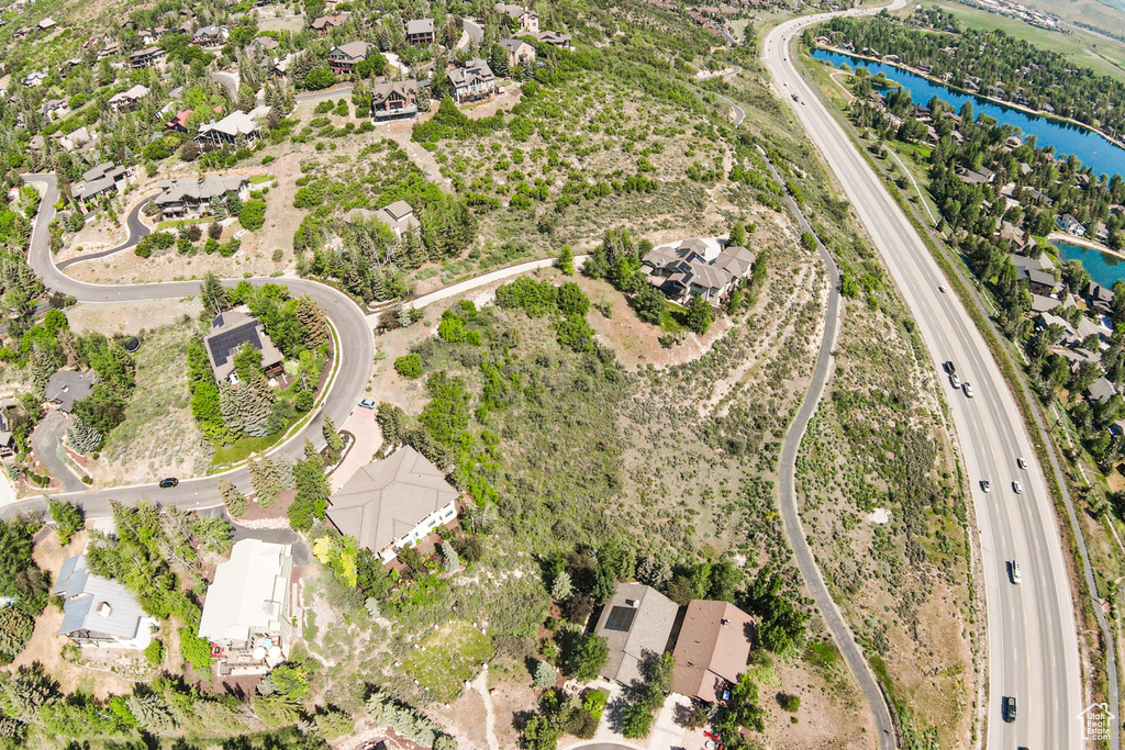 Aerial perspective of suburban area with a nearby body of water and a major roadway