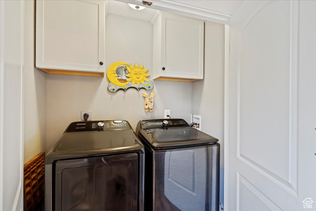 Washroom featuring washing machine and clothes dryer and cabinet space