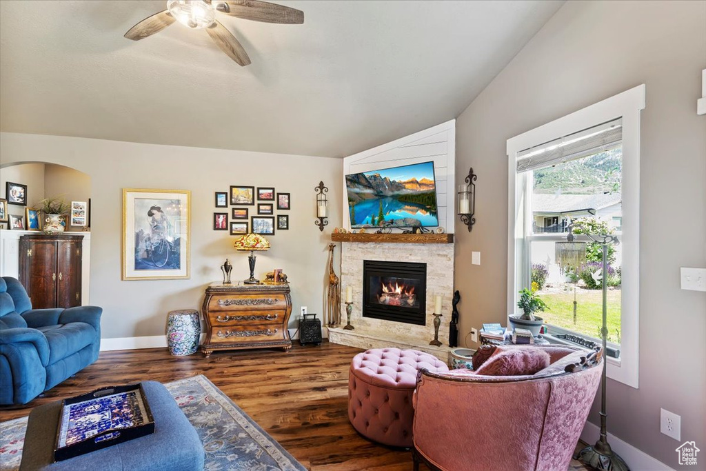 Living room with wood finished floors, a fireplace, and ceiling fan