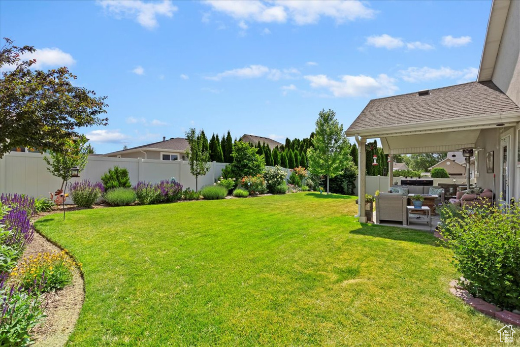 Fenced backyard with a patio and outdoor lounge area