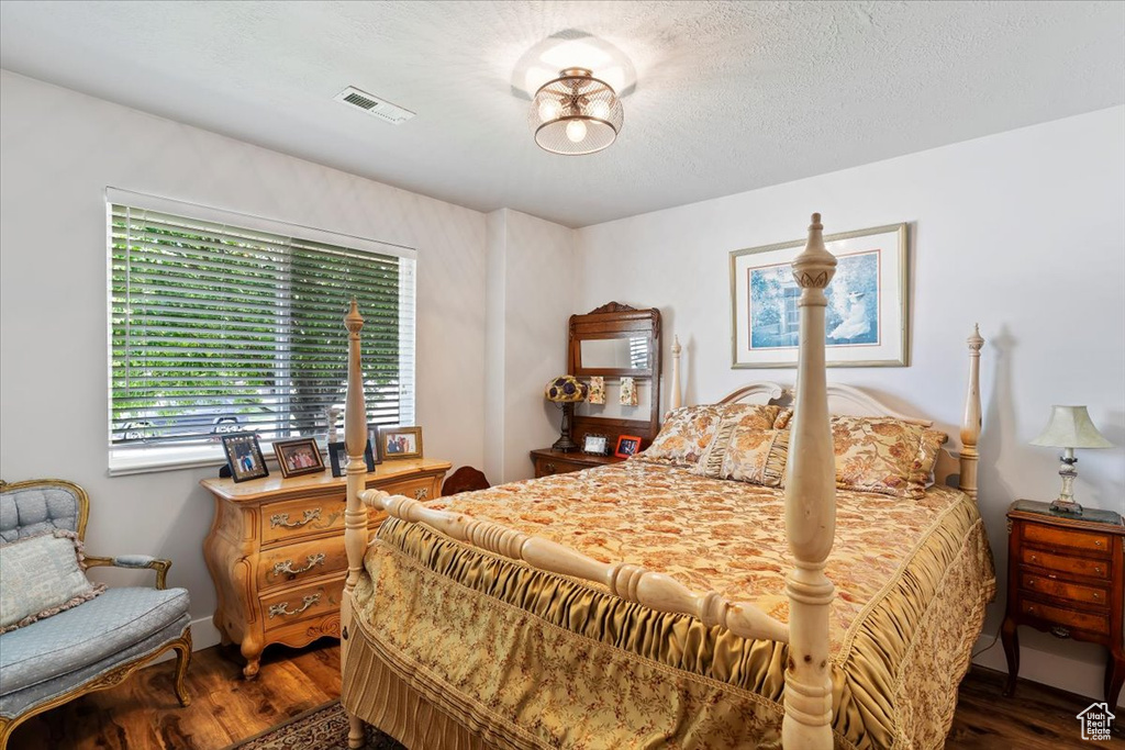 Bedroom featuring wood finished floors and a textured ceiling