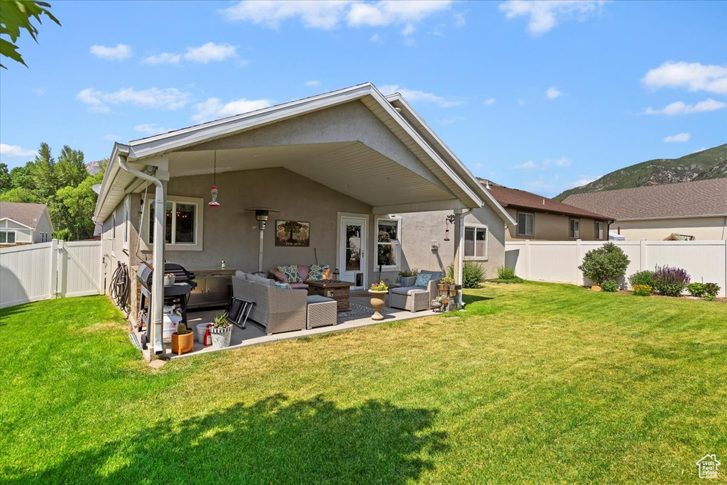 Rear view of house featuring an outdoor living space, stucco siding, a fenced backyard, a patio area, and a gate