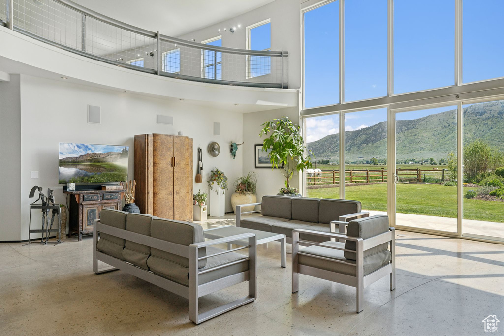 Living room with a towering ceiling, a mountain view, and healthy amount of natural light