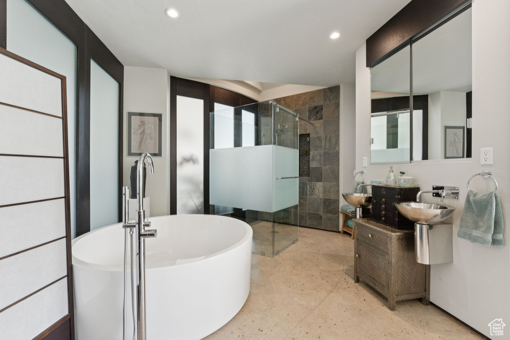 Full bath with a stall shower, recessed lighting, a soaking tub, and a sink