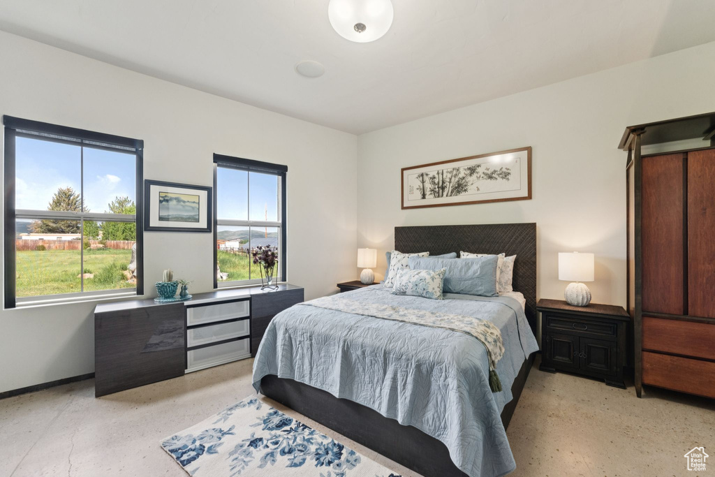 Bedroom featuring multiple windows and baseboards