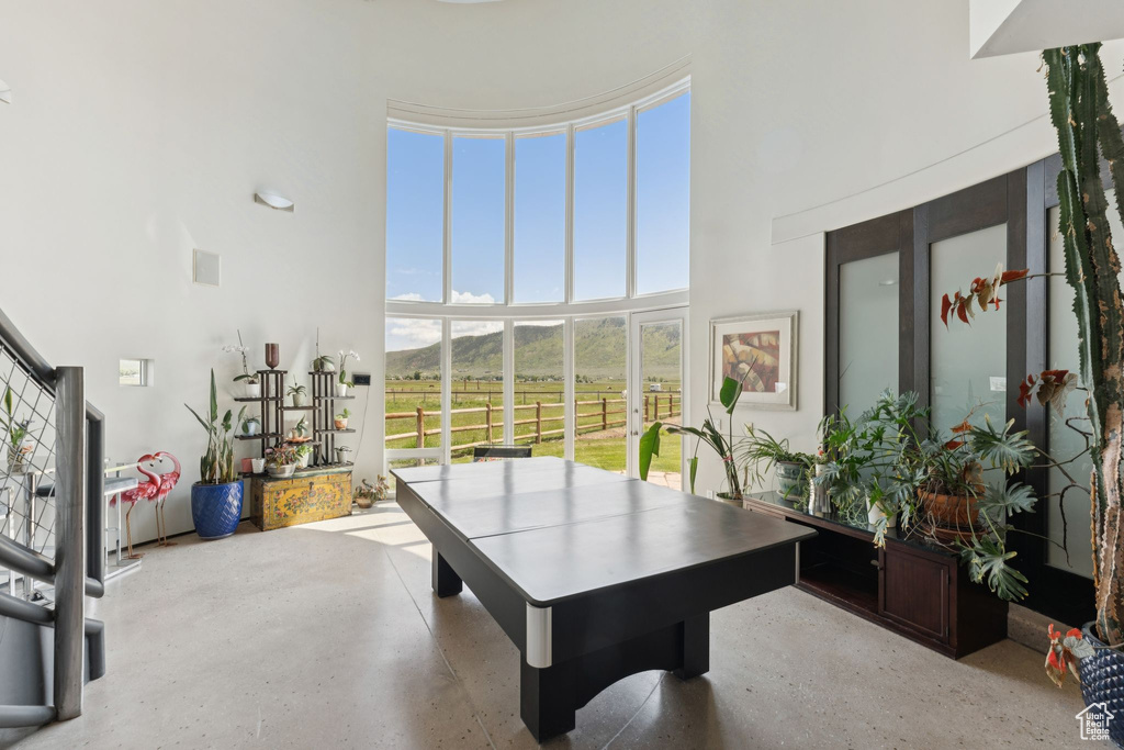 Playroom featuring a high ceiling, speckle patterned floor, and a rural view