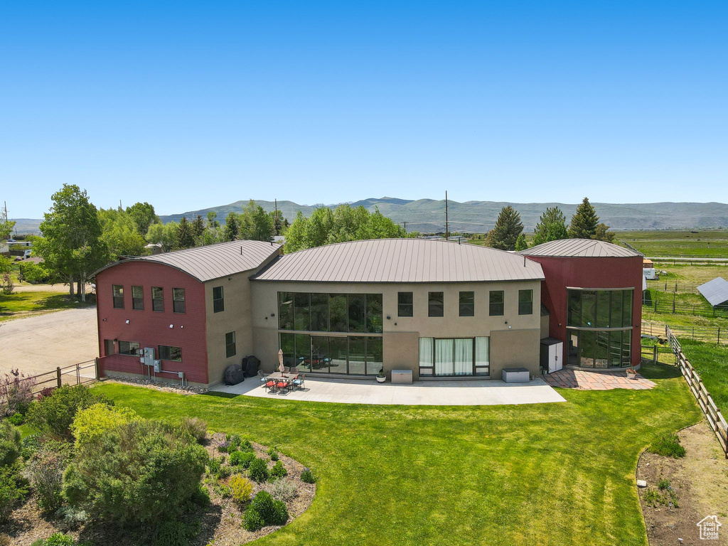 Back of property featuring stucco siding, a patio, metal roof, and a mountain view