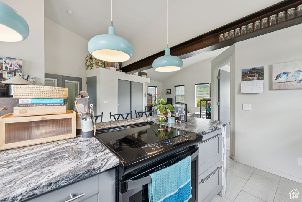 Kitchen featuring black / electric stove, vaulted ceiling, pendant lighting, light tile patterned floors, and stone counters