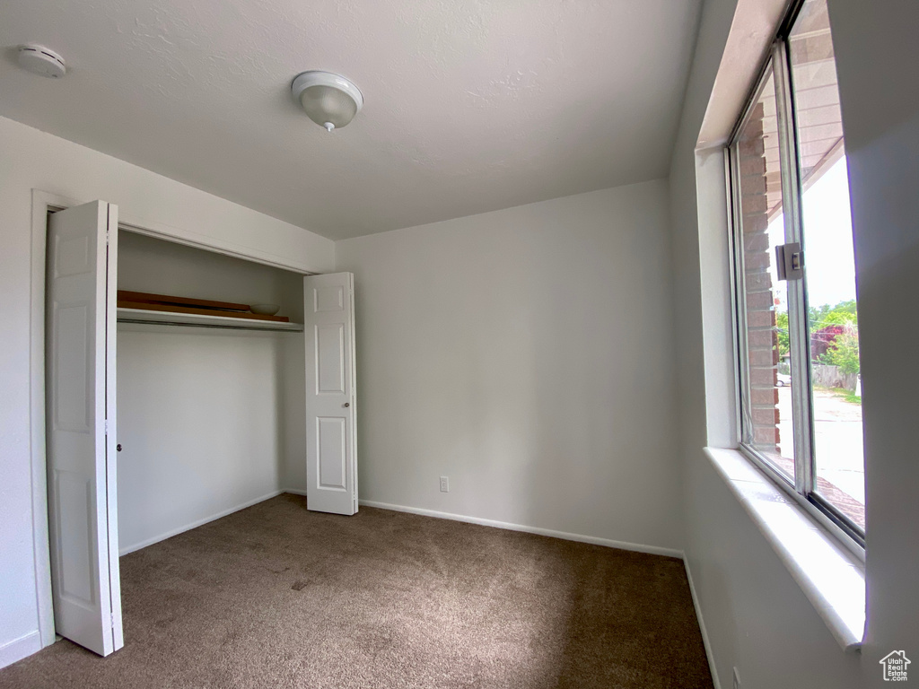 Unfurnished bedroom with carpet flooring, baseboards, and a closet