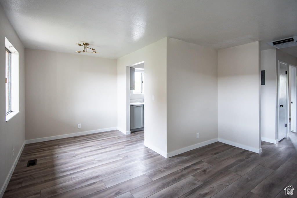 Spare room with plenty of natural light, wood finished floors, and baseboards