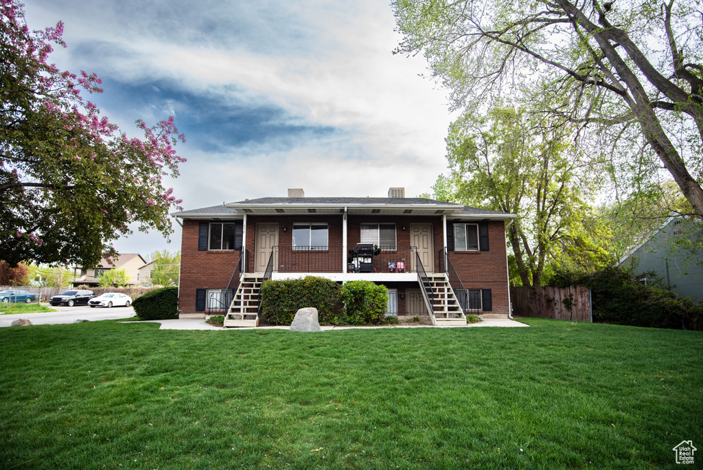 Rear view of house with stairway, brick siding, and a chimney