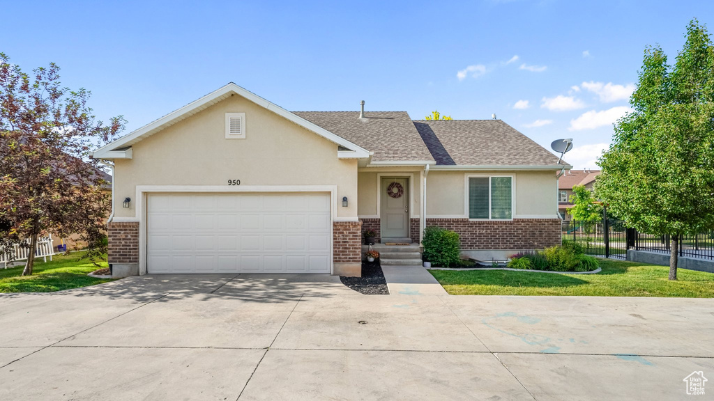 View of front of house with stucco siding, brick siding, concrete driveway, a garage, and roof with shingles