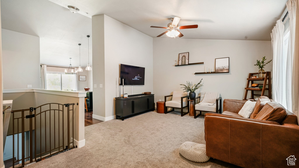 Living room with carpet, ceiling fan, vaulted ceiling, and baseboards