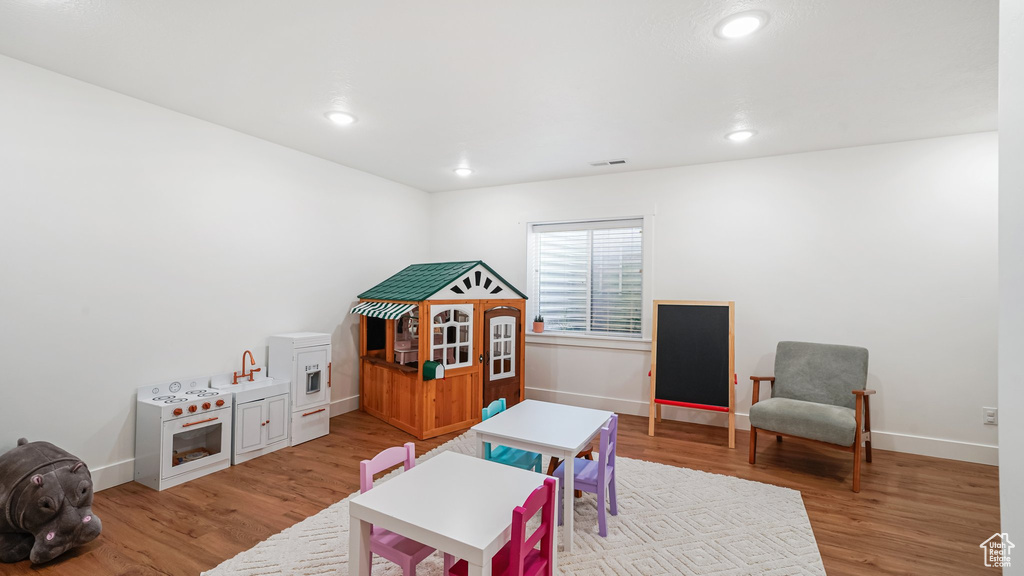 Playroom featuring light wood-type flooring, baseboards, a sink, and recessed lighting