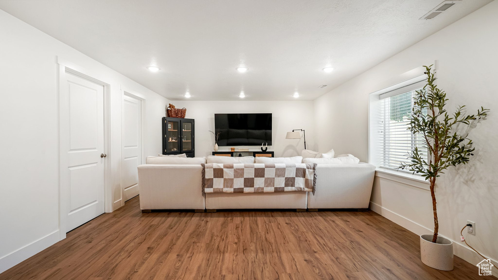 Living area with wood finished floors, baseboards, and recessed lighting