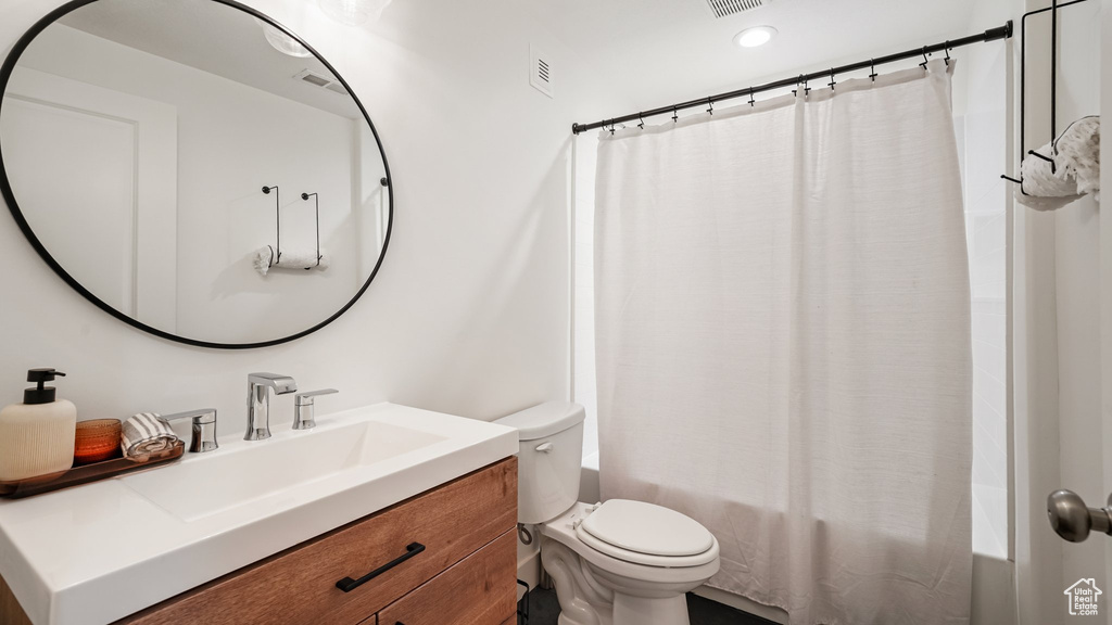 Bathroom with vanity, toilet, shower / bath combo, and recessed lighting
