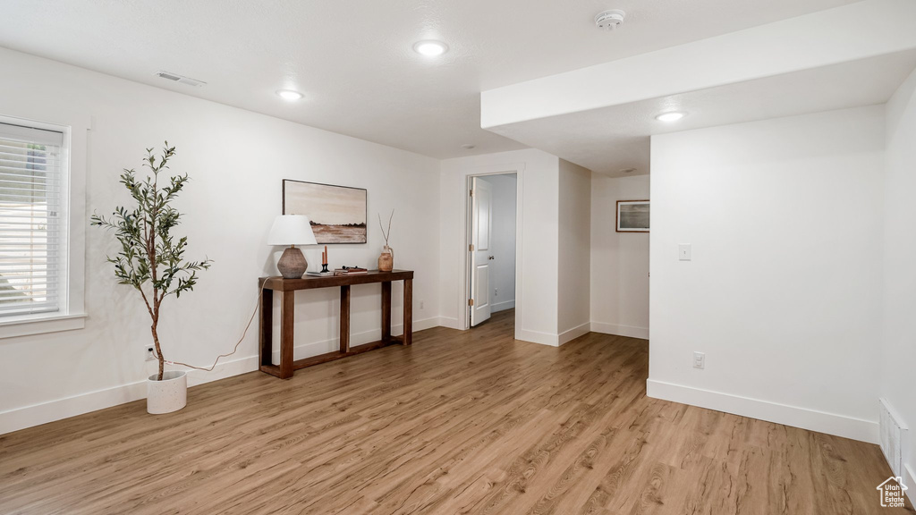 Spare room featuring light wood finished floors, a smoke detector, baseboards, and recessed lighting