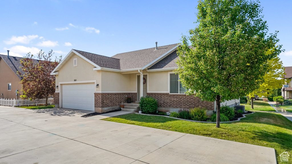 View of front of property featuring concrete driveway, stucco siding, a garage, brick siding, and a shingled roof