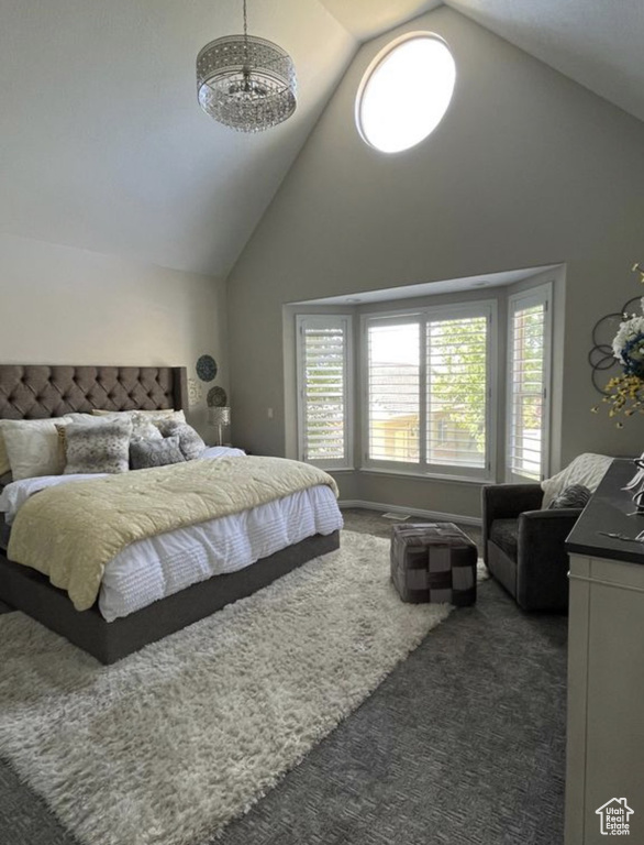 Bedroom with high vaulted ceiling, carpet, and a chandelier