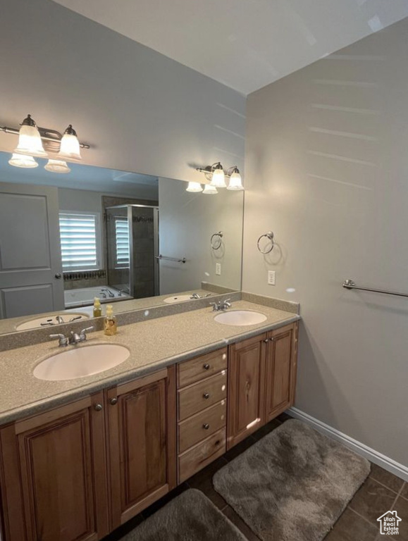 Full bath with double vanity, a shower stall, a bath, and tile patterned flooring