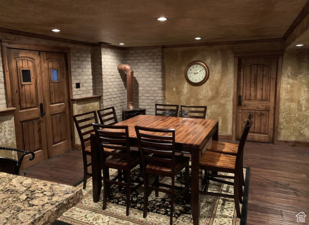 Dining space featuring wood finished floors, recessed lighting, and crown molding