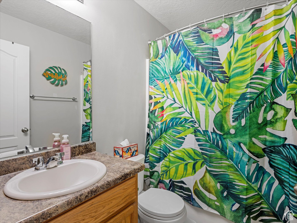 Bathroom with vanity, a textured ceiling, and a shower with curtain
