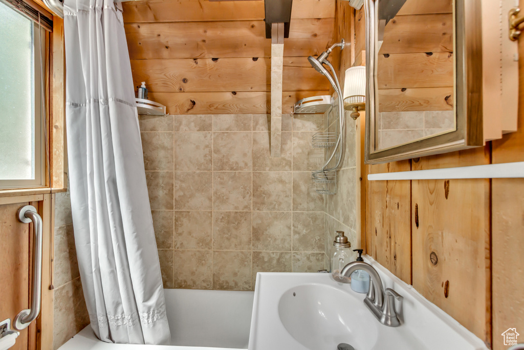 Full bath with shower / tub combo with curtain and a sink