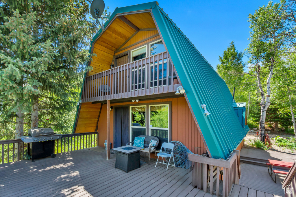 Wooden deck featuring grilling area and a fire pit