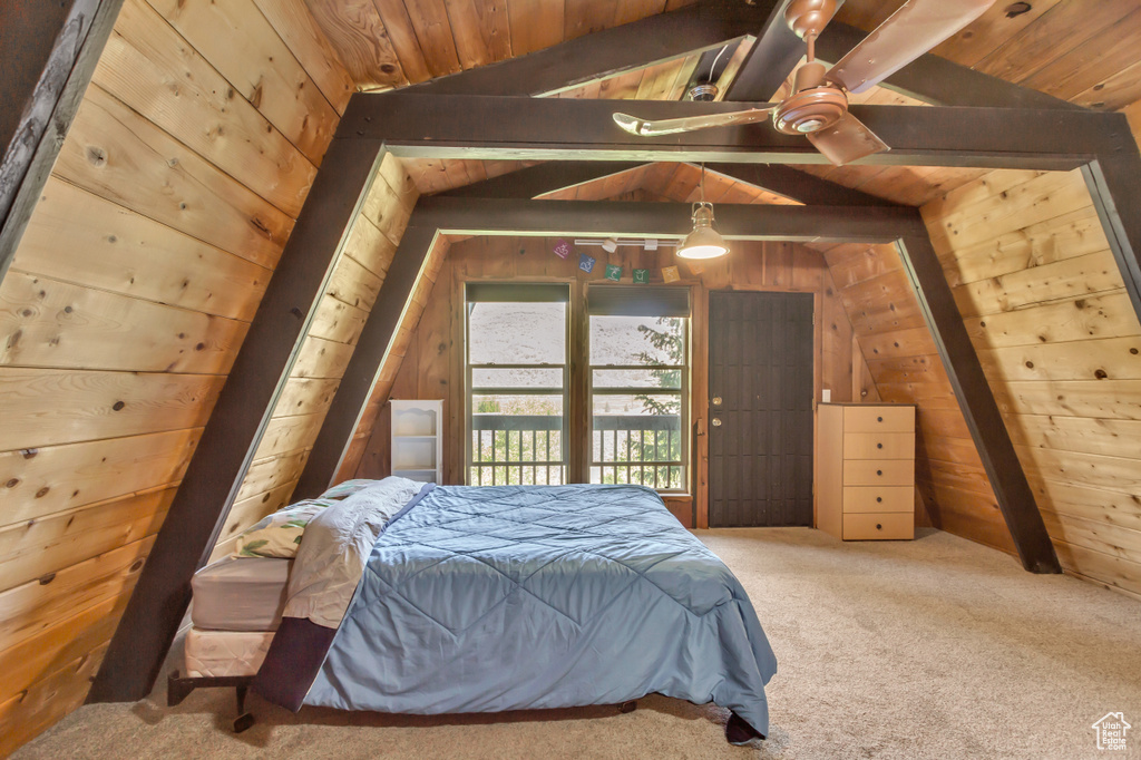 Bedroom with wood ceiling, wood walls, carpet flooring, and access to exterior